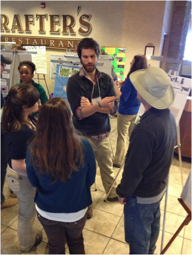 Our intern Kyle (at center) gathering a crowd at his poster presentation, entitled “Lewis and Clark and You.” Photo credit: Josh Angelini 